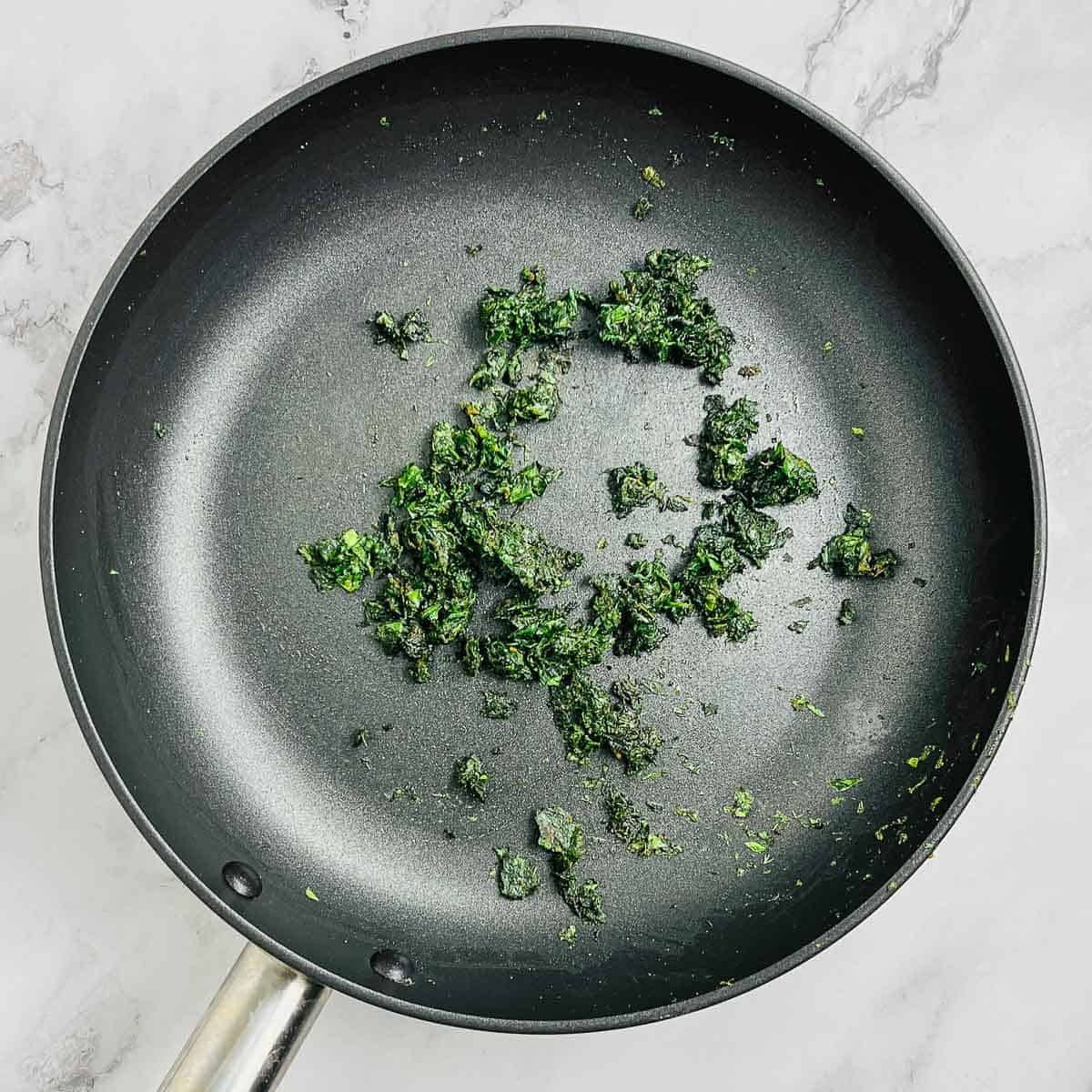 Sauted greens in a frying pan.