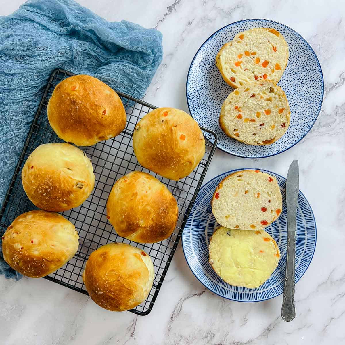 Bun maska buns on wire rack and plates.