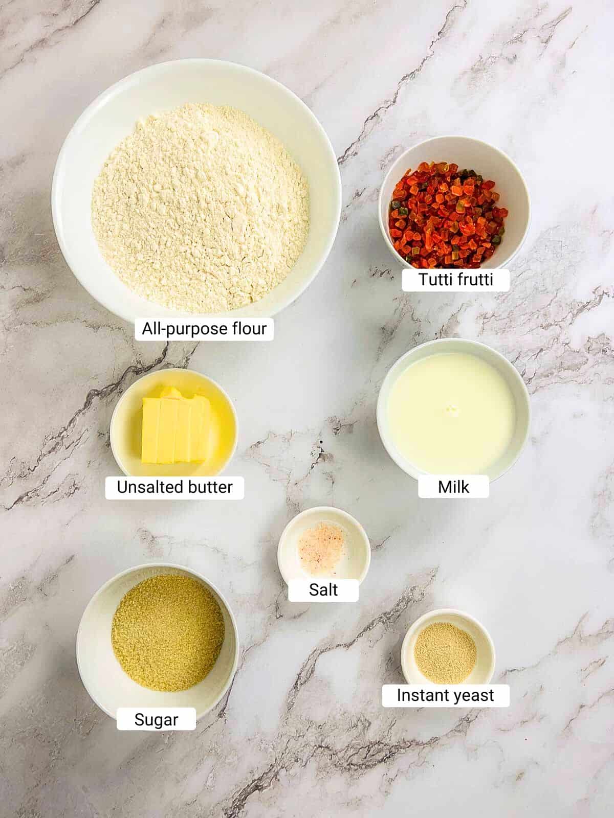 Ingredients to make bun maska on a marble surface.