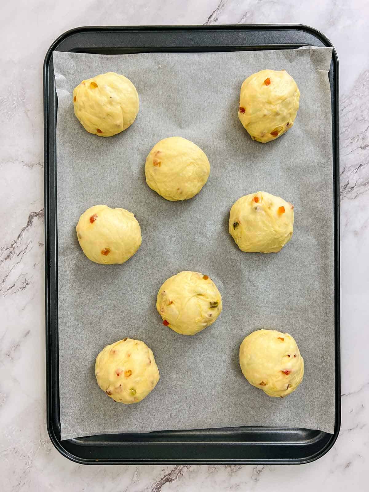 Shaped buns on a baking sheet.