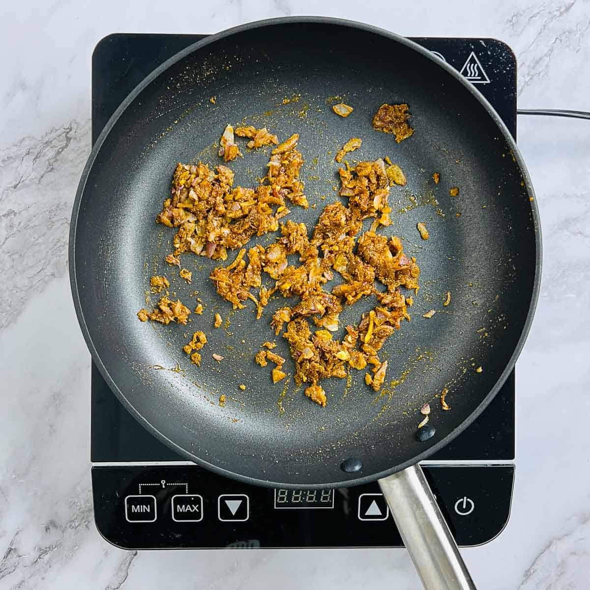 Sauted onion, garlic, and spices in a skillet.