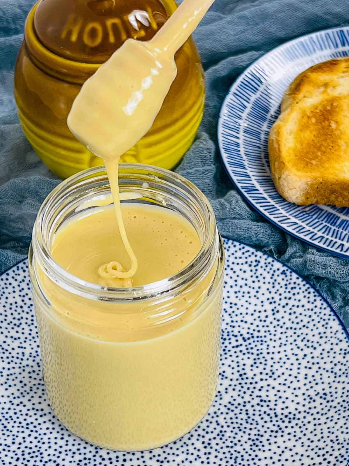 Whipped honey dripping from a honey drizzle spoon.