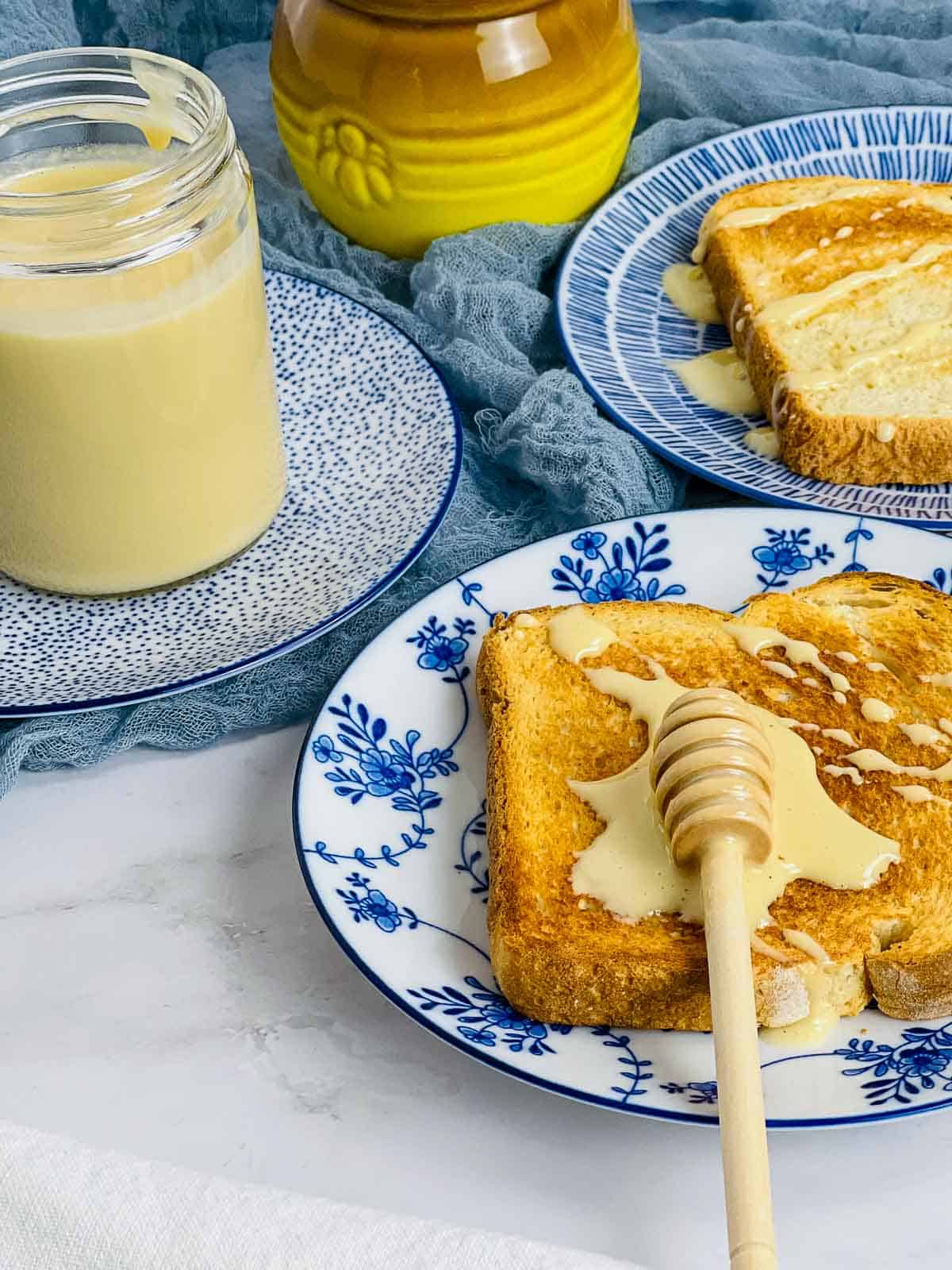 Whipped honey on a toast with honey jar in the background.