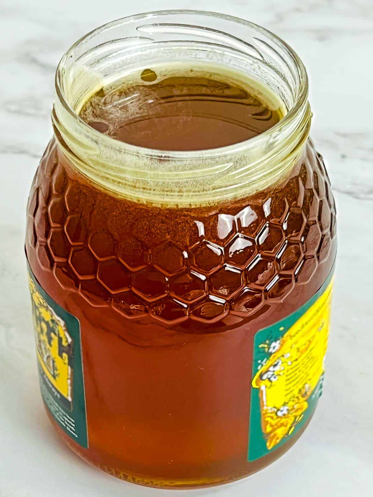 Raw honey as an ingredient placed on a marble surface.