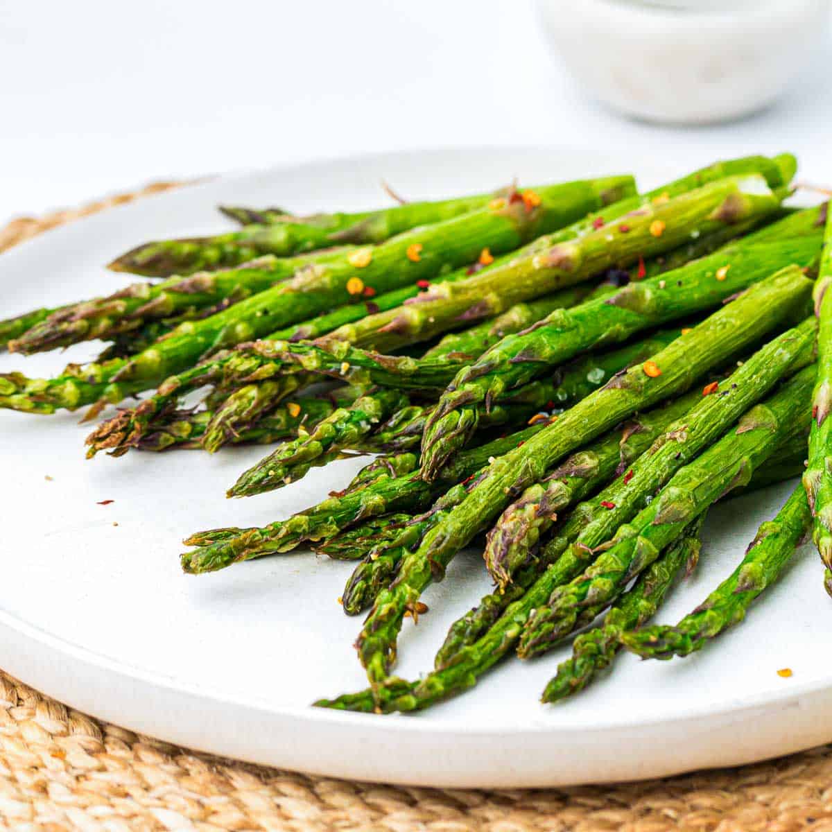 Side view of asparagus placed on a round plate.