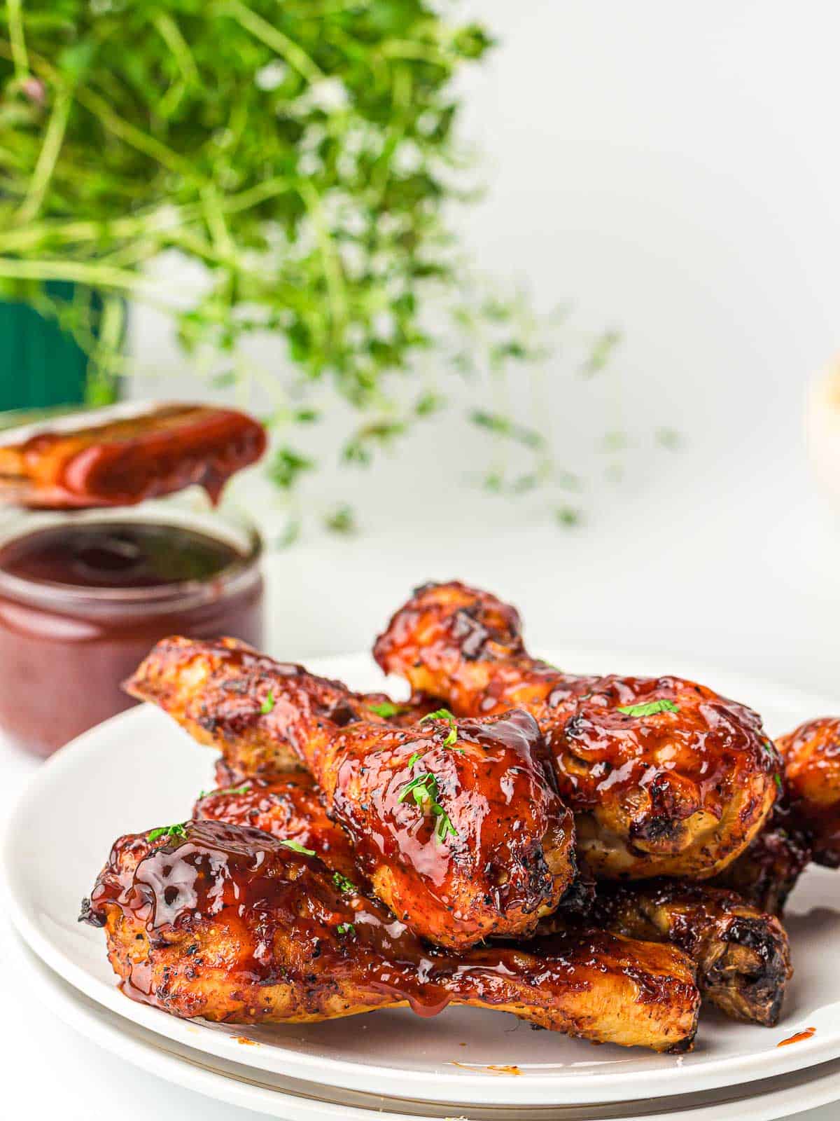 Air fryer BBQ chicken stacked on a white plate.