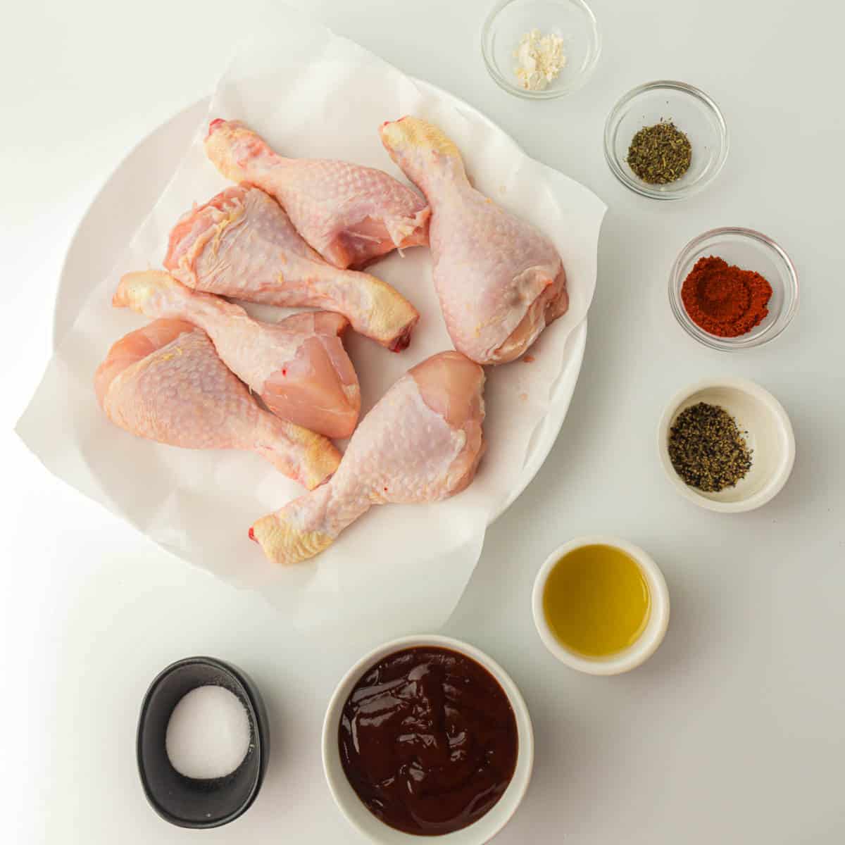 Ingredients to make Bbq chicken on a white surface.