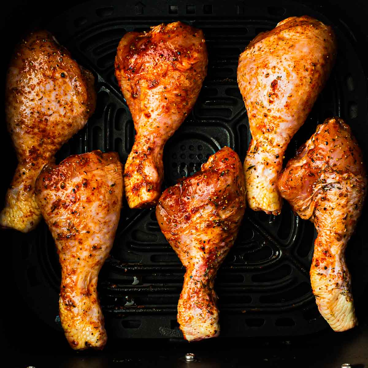 Seasoned drumsticks in air fryer.