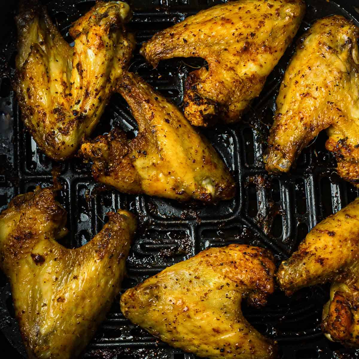 Roasted chicken wings in air fryer basket.