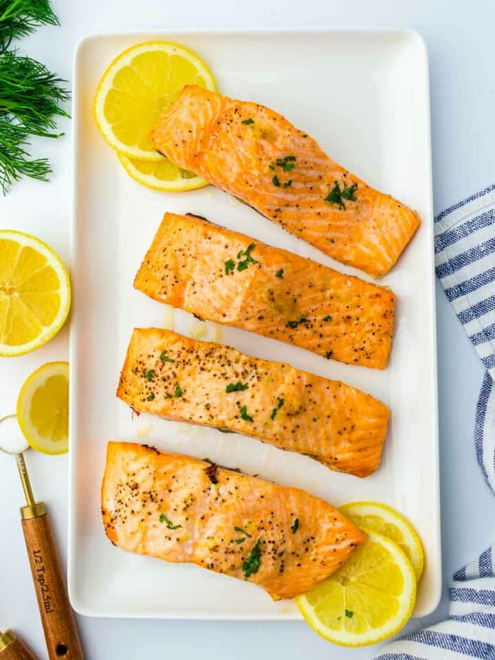 Air fryer salmon served with lemon wedges on a rectangular plate.