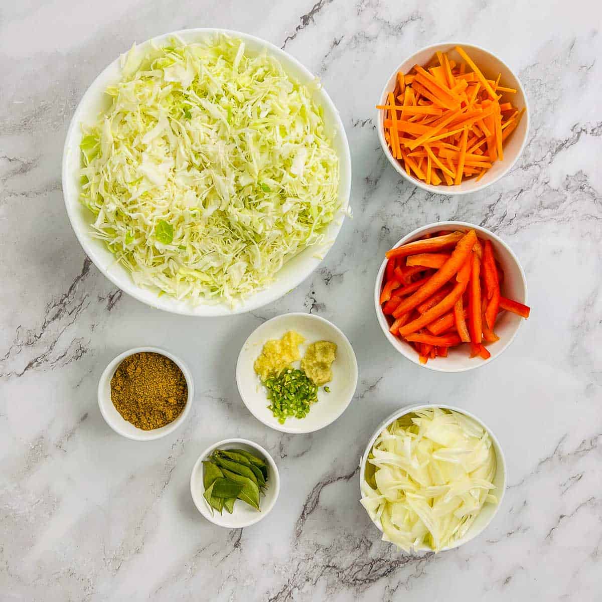 Ingredients required to make the dish placed on a marble surface.