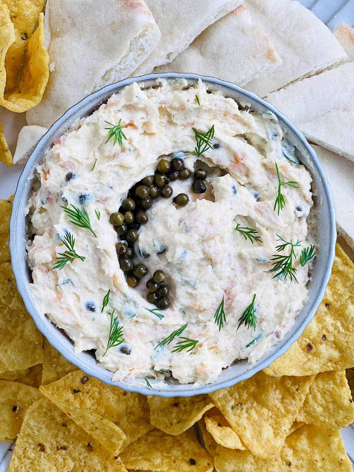 Salmon egg dip topped with green peppercorns and served with dippers.