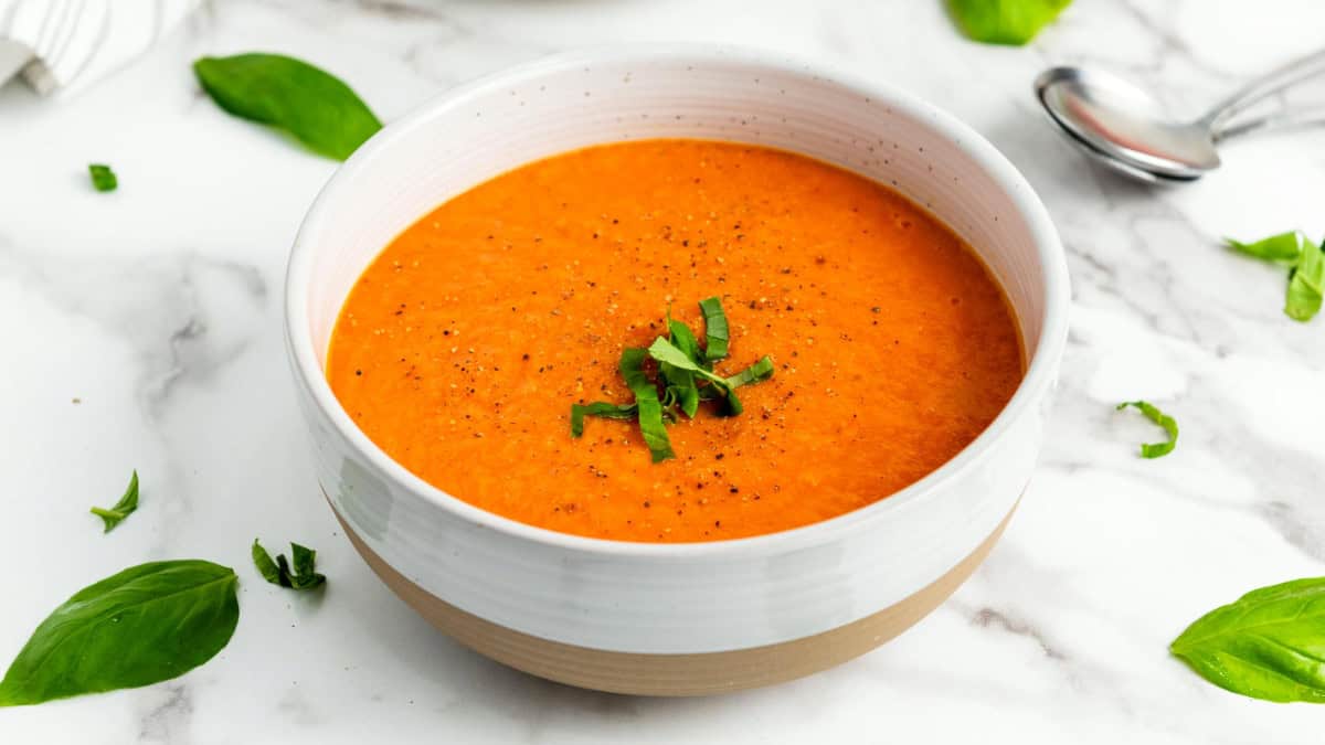 Transfer the soup into bowl and garnish with basil leaves.