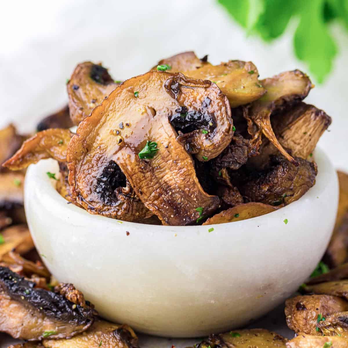 Garlic mushrooms in a white bowl.