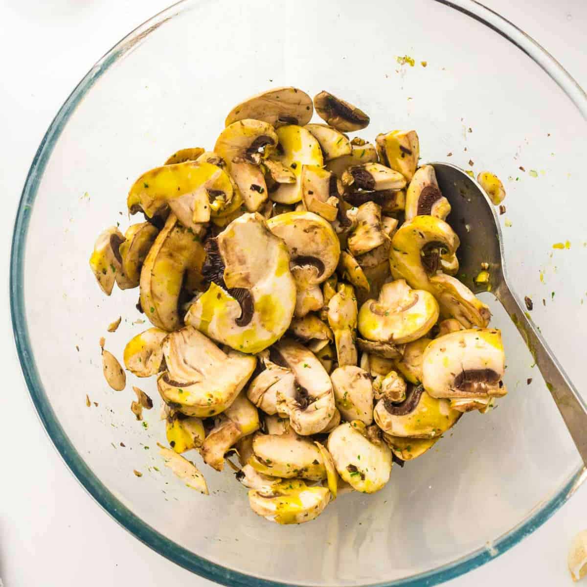 Seasoned mushrooms in a mixing bowl.