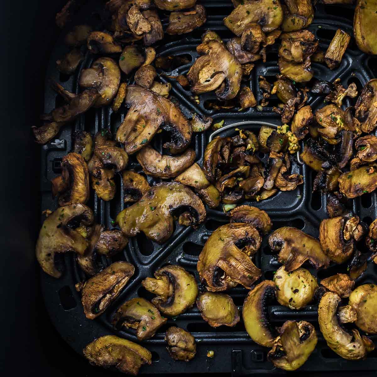 Roasted mushrooms in air fryer basket.