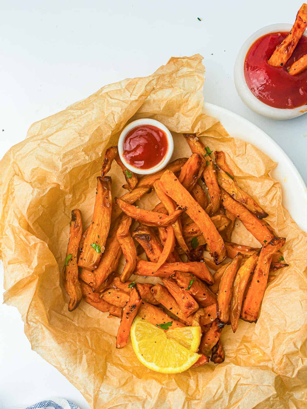 Sweet potato fries served on a baking sheet with ketchup.