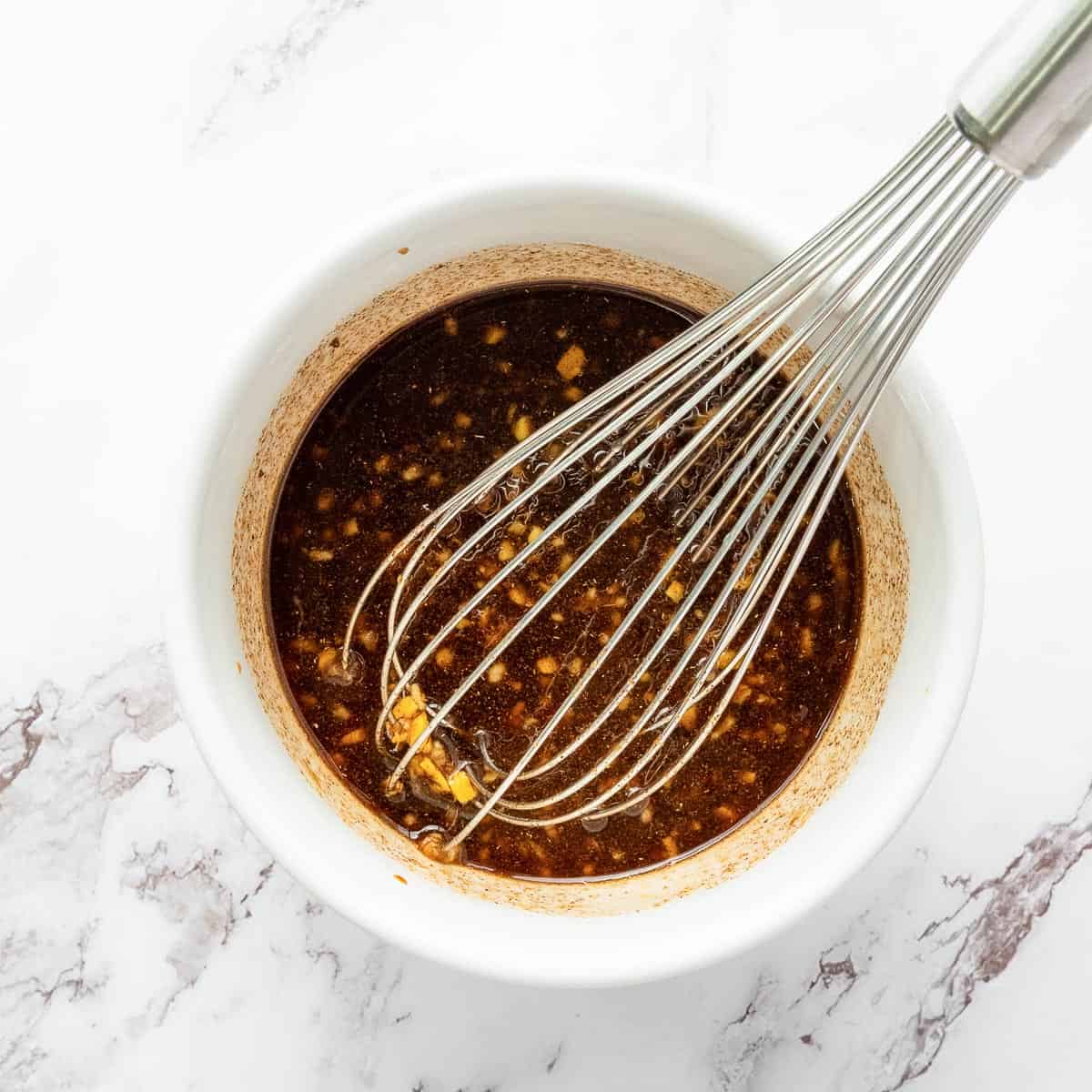 Whisked marinade in a white bowl.