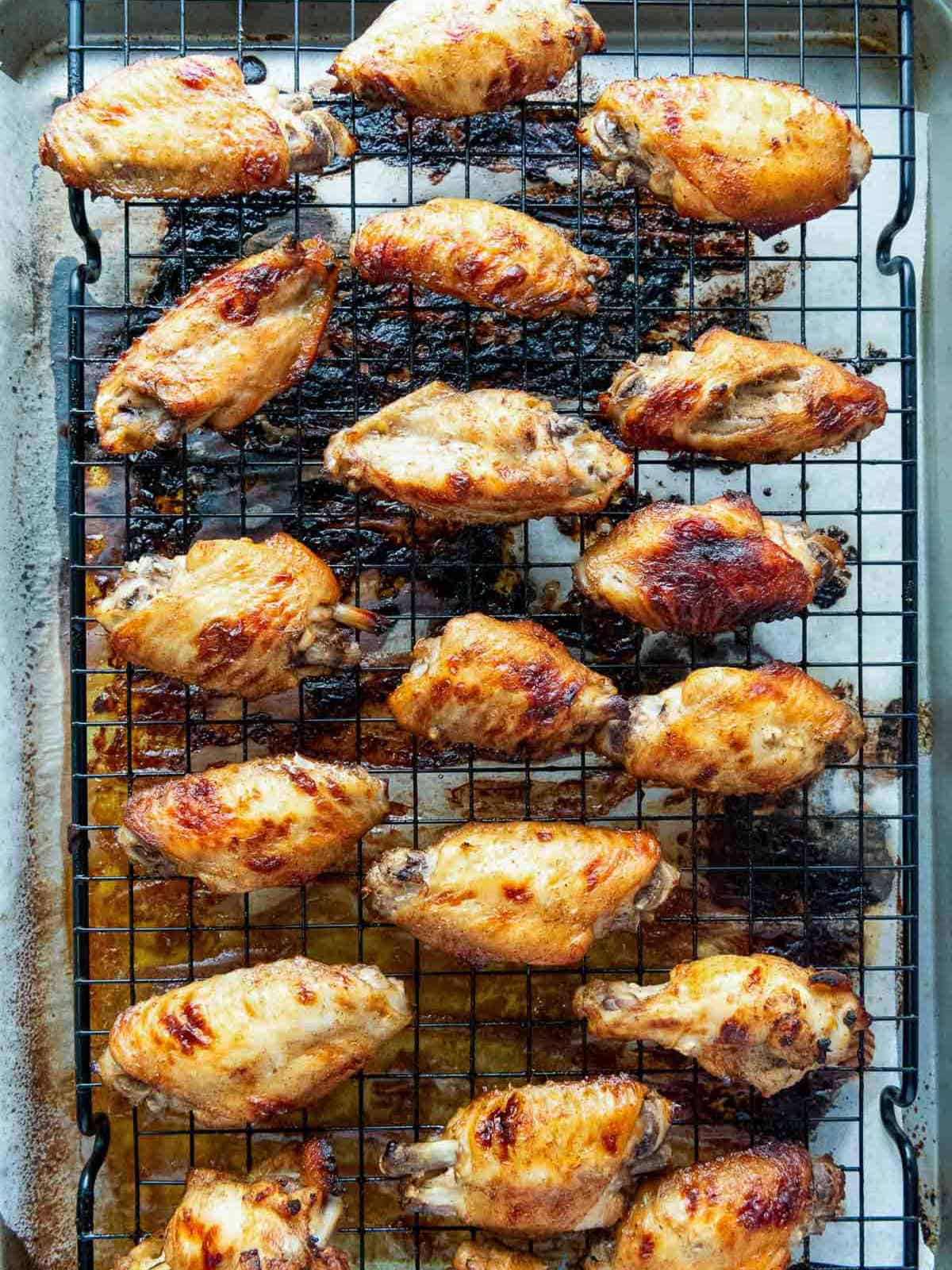 Baked chicken wings on a wire rack.