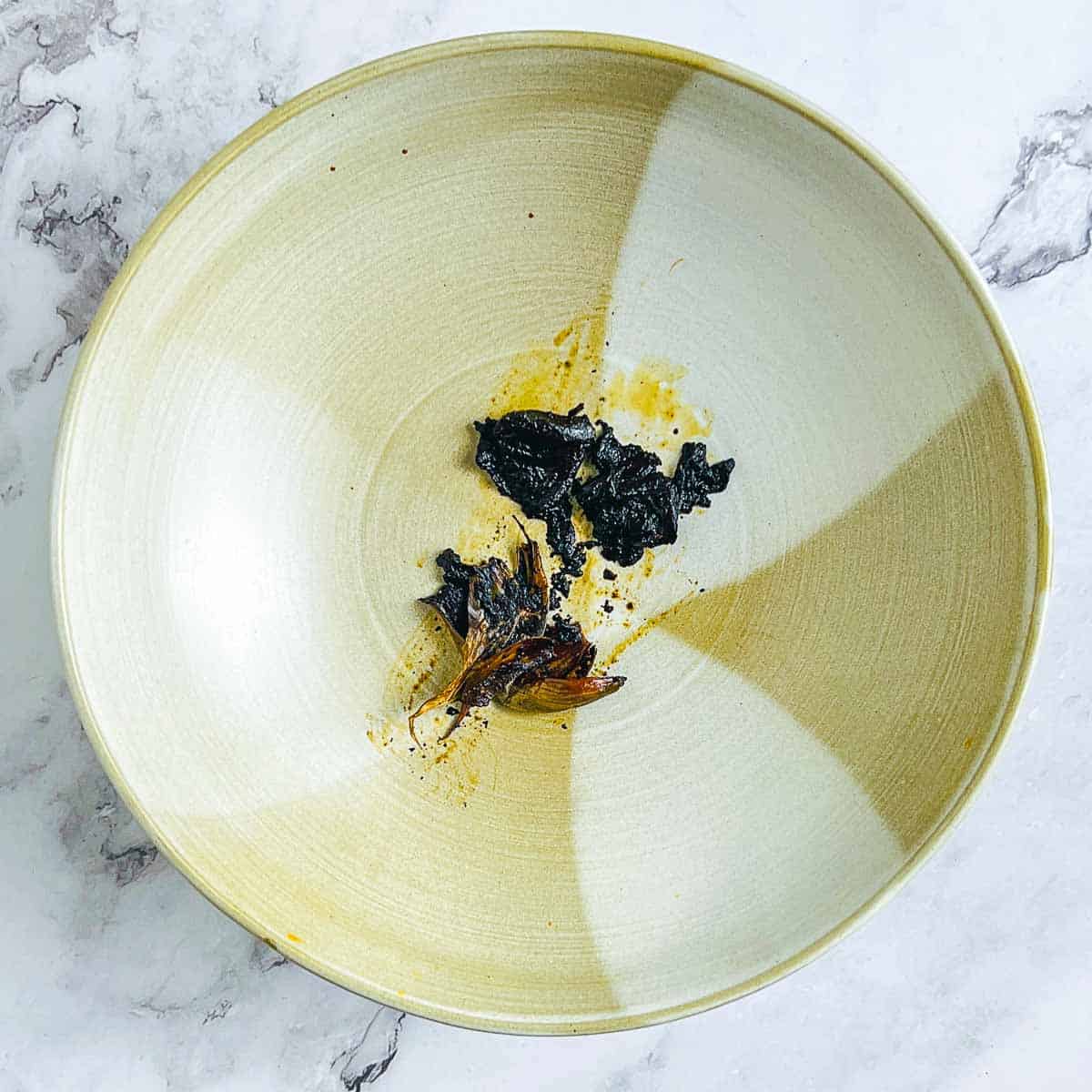 Peeled and mashed black garlic in a bowl.