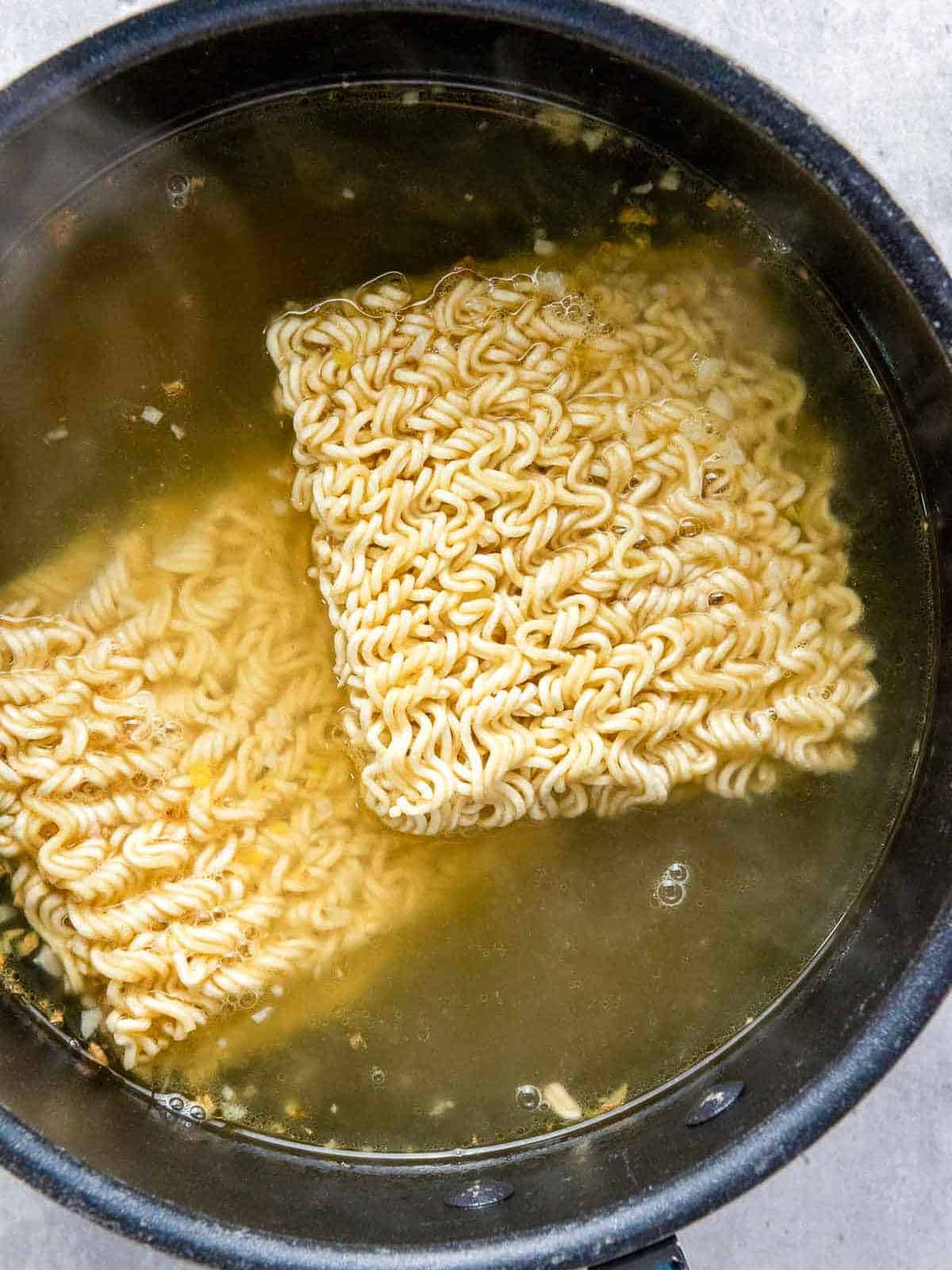 Broth and noodles added to the pan.