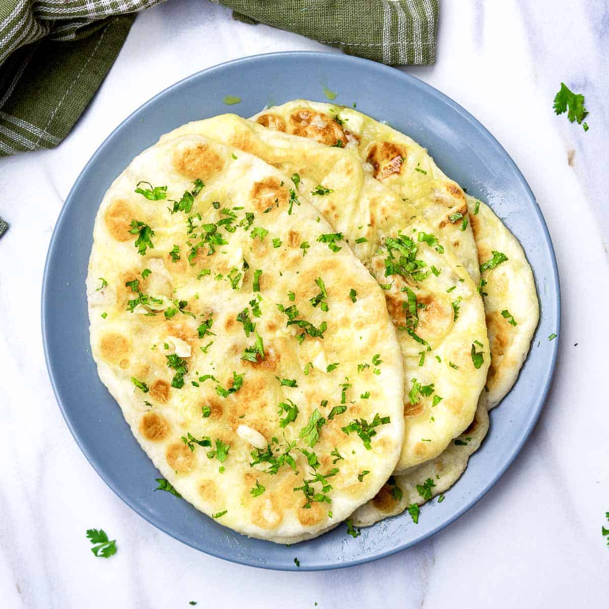 A stack of garlic naan on a blue plate.