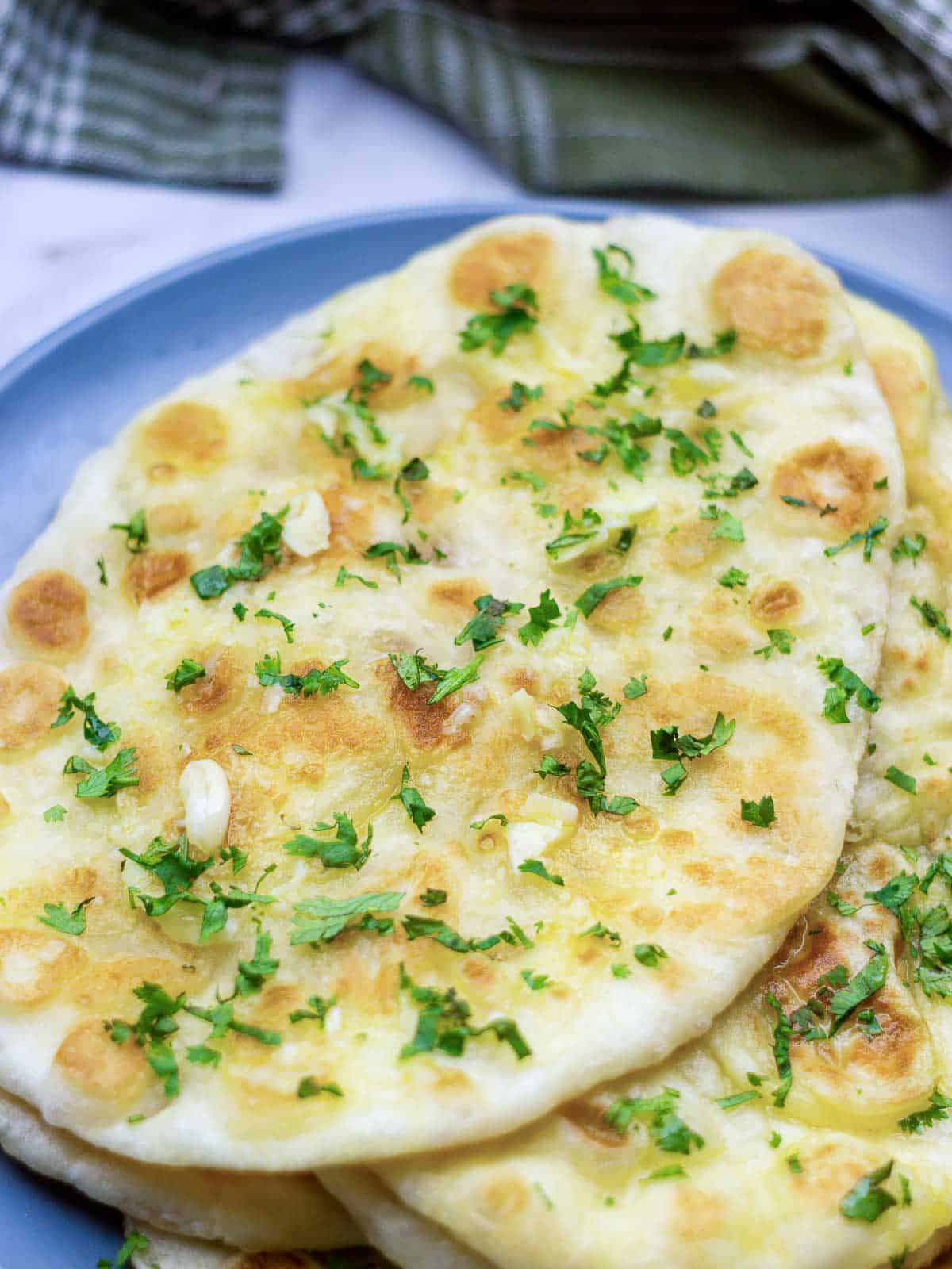 Garlic naan on a blue plate.