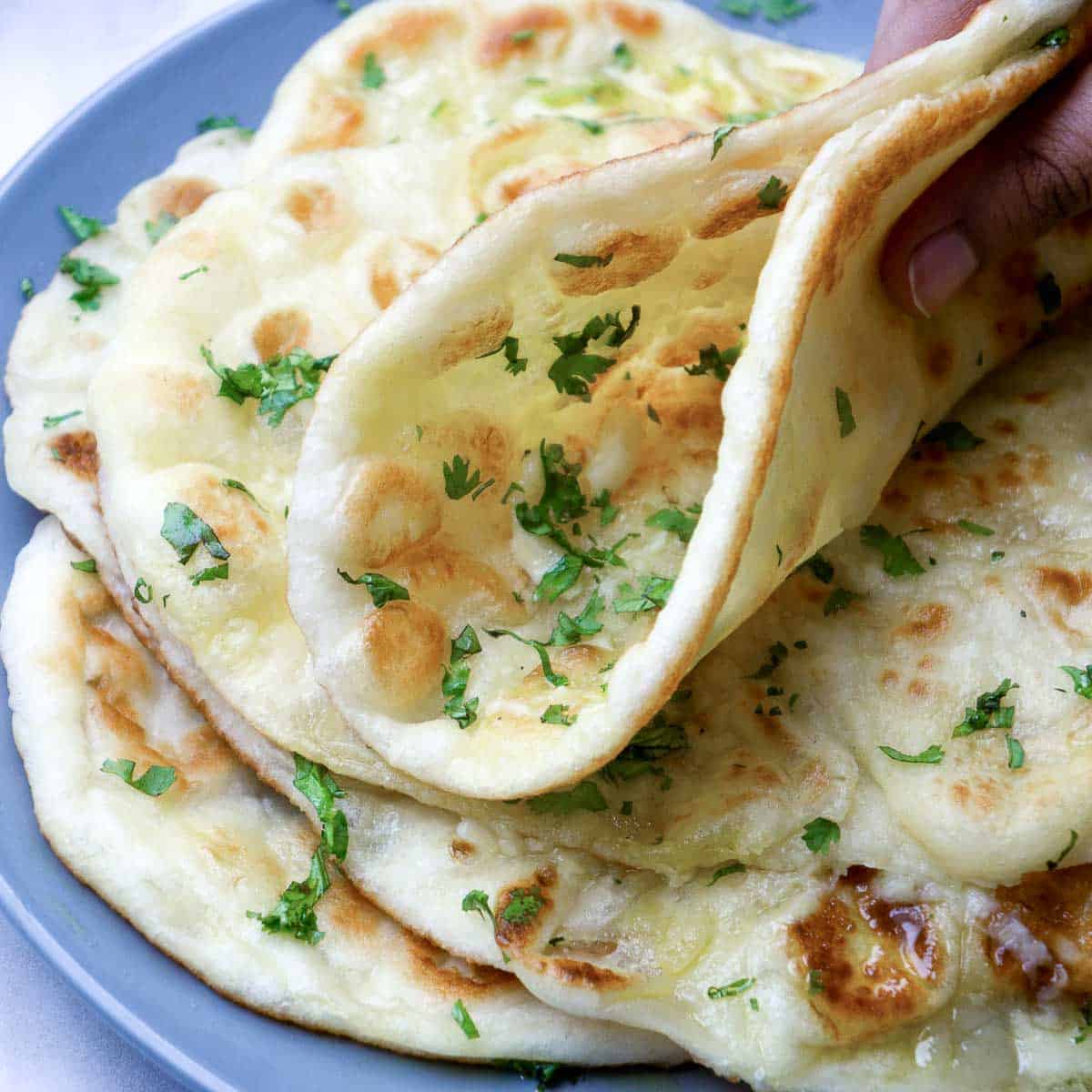 Soft and fluffy garlic naan folded to show texture.