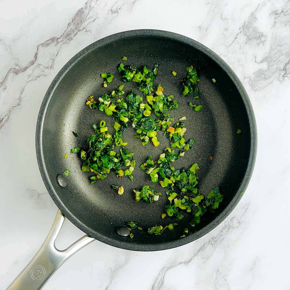 Sauted green onions and garlic in the frying pan.