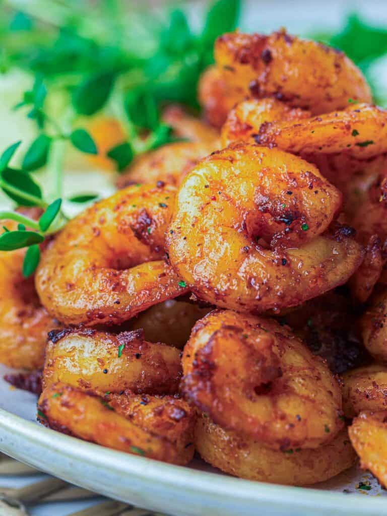 Close up of air fryer shrimp placed on a white plate.