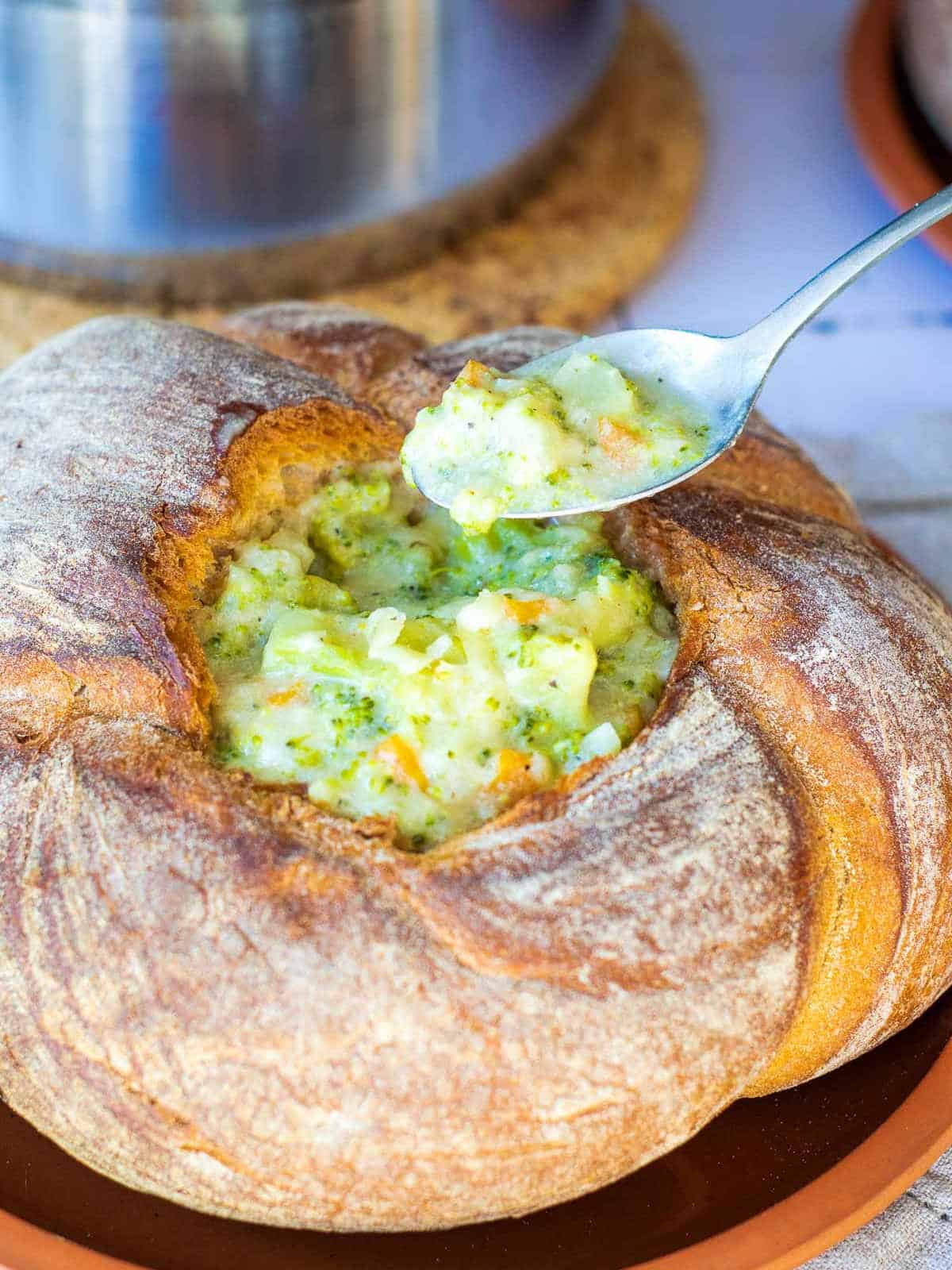 Creamy broccoli cheddar soup on a spoon.