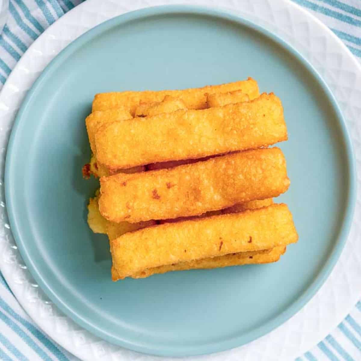 Deep fried potato sticks placed on a blue plate.