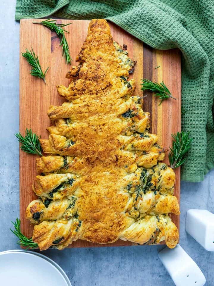 Spinach dip breadsticks on a wooden board.