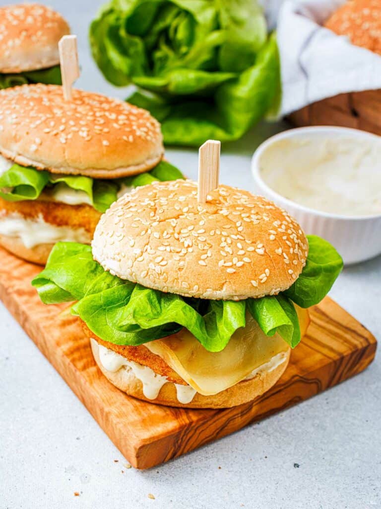 Filet-o-fish burgers with lettuce and tartar sauce in the background.