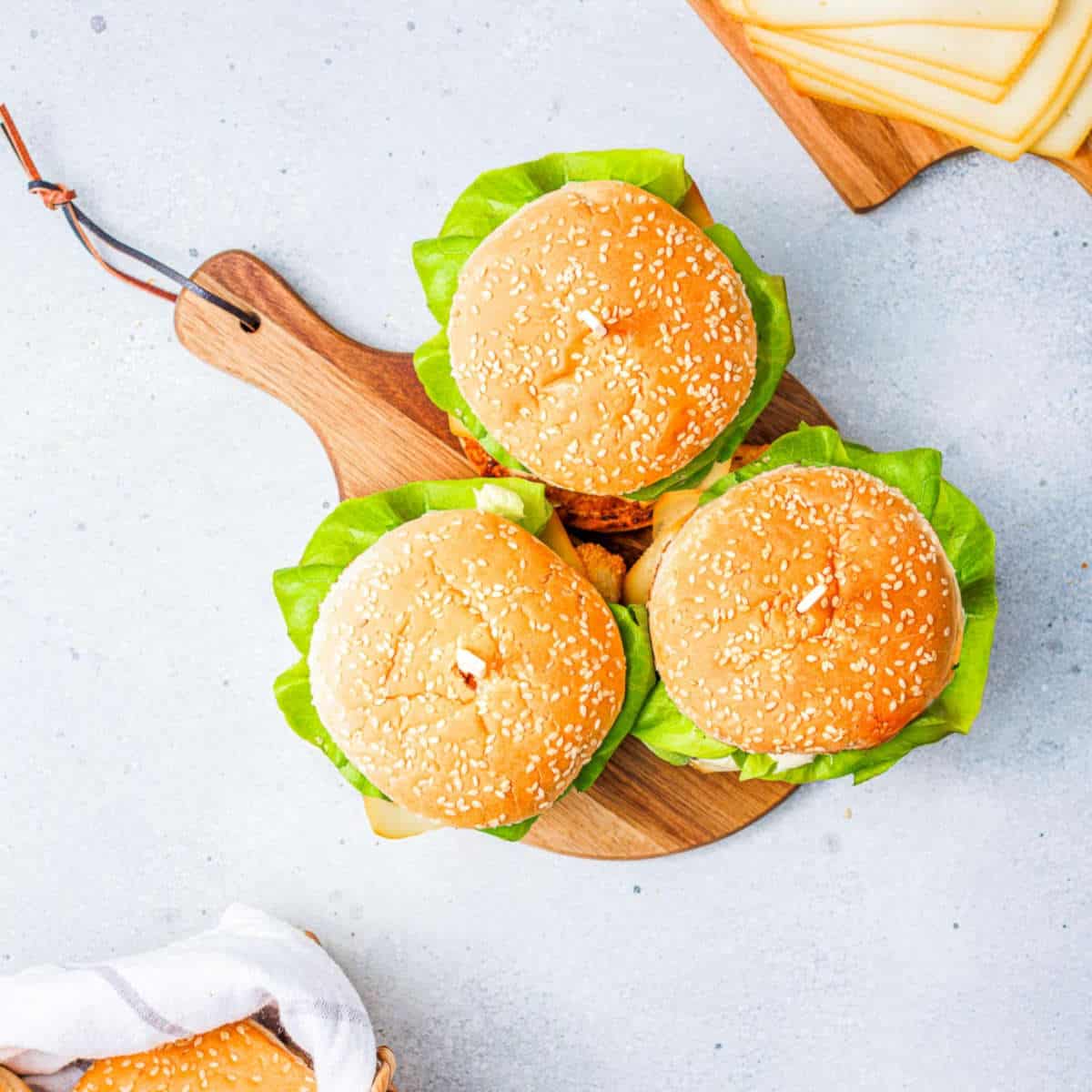 Assembled burgers on a round board.