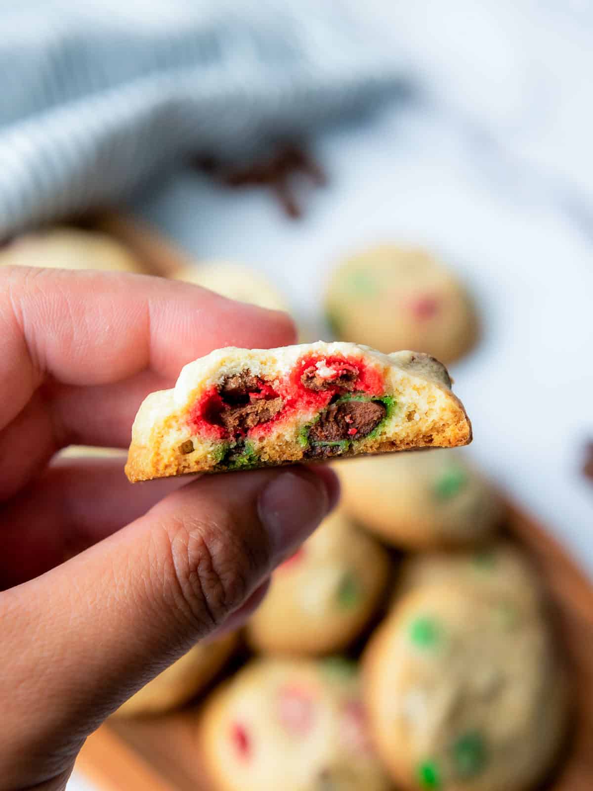 Holding M&M cookies to show the soft center.