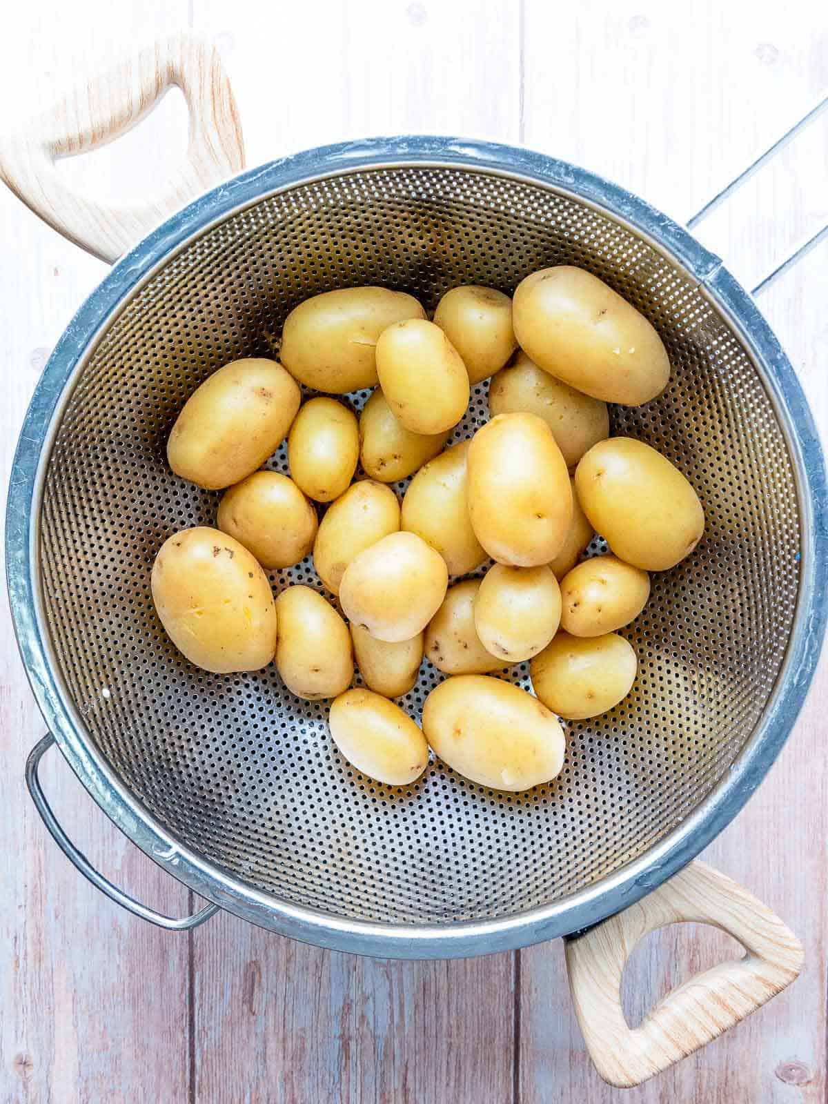 Boiled potatoes in a strainer.