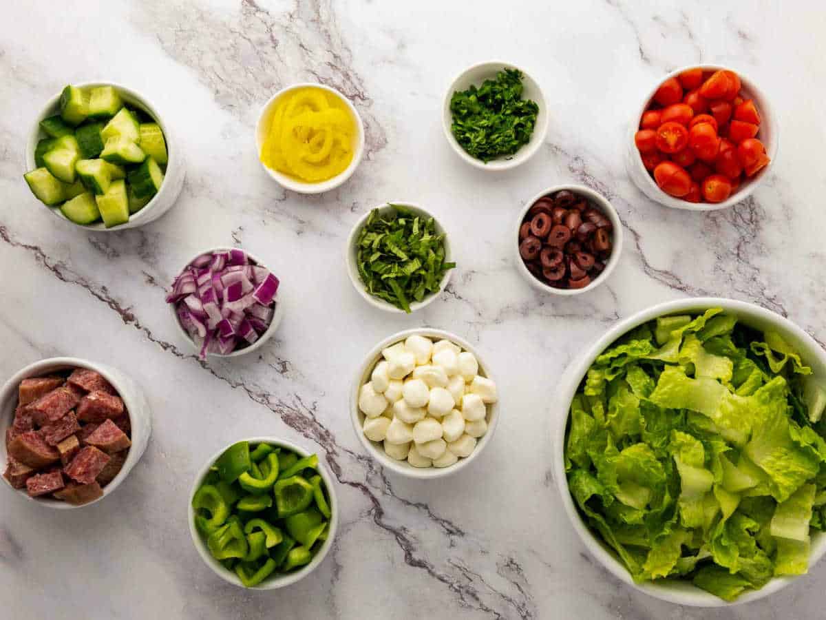 Salad ingredients placed on a marble surface.