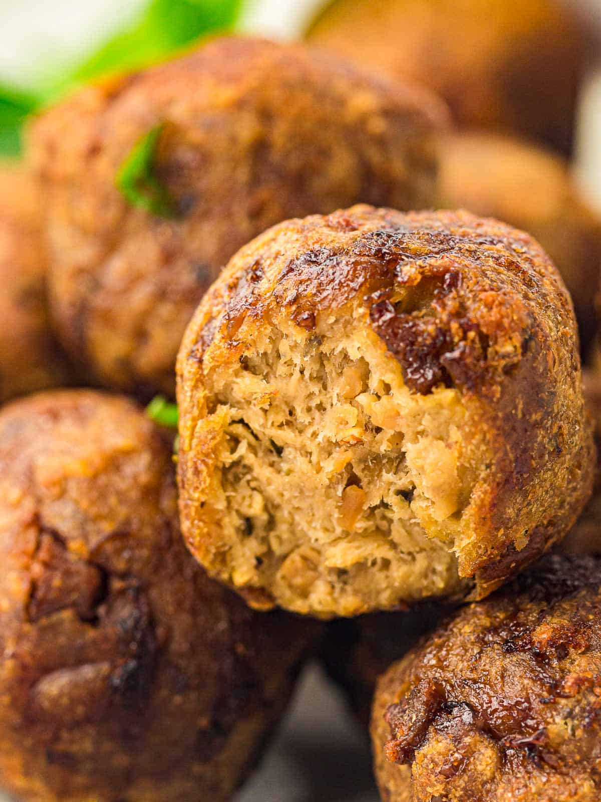 Close up of a cooked meatball from a stack of meatballs.