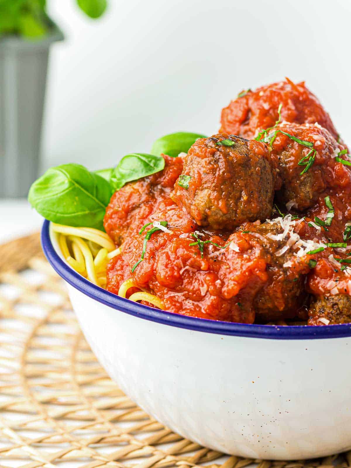 Meatballs served on a bed of spaghetti and sauce.