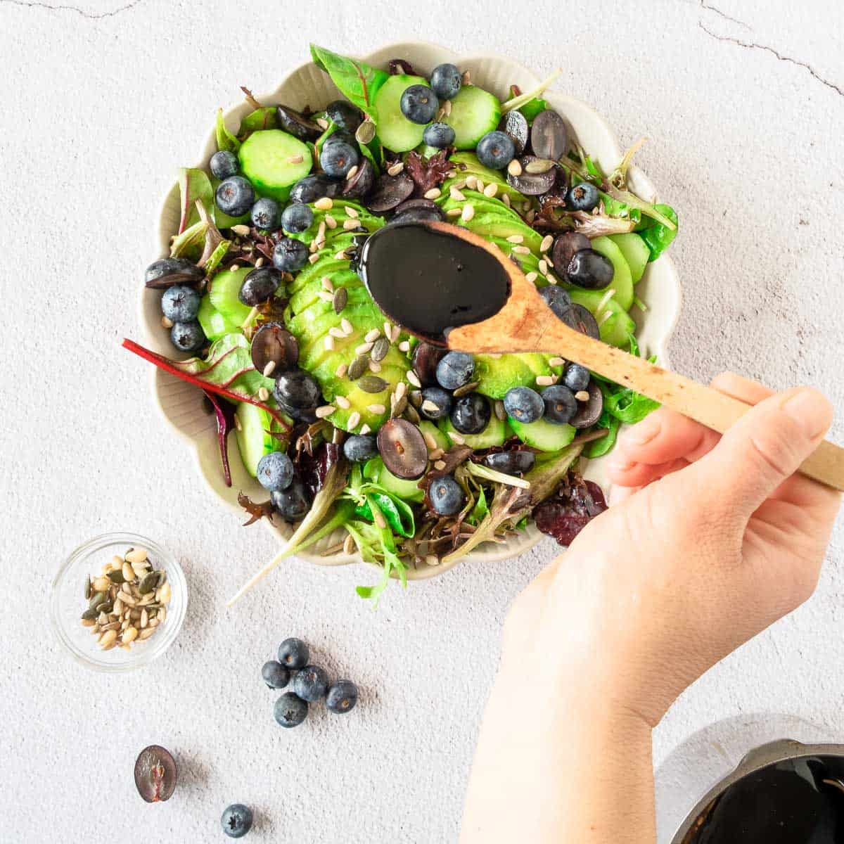 Pouring balsamic glaze using a wooden spoon.