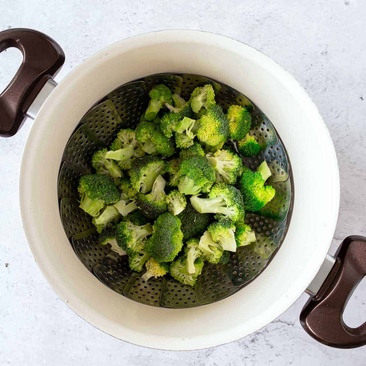 Steamed broccoli in a colander.