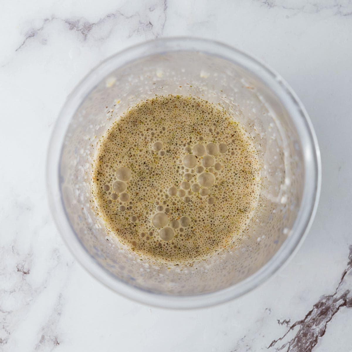 All dressing ingredients mixed in a glass bowl.