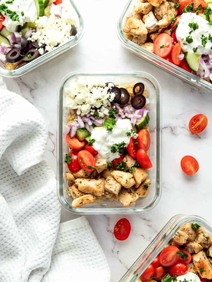 Boxes of Mediterranean chicken quinoa bowls on a white surface.