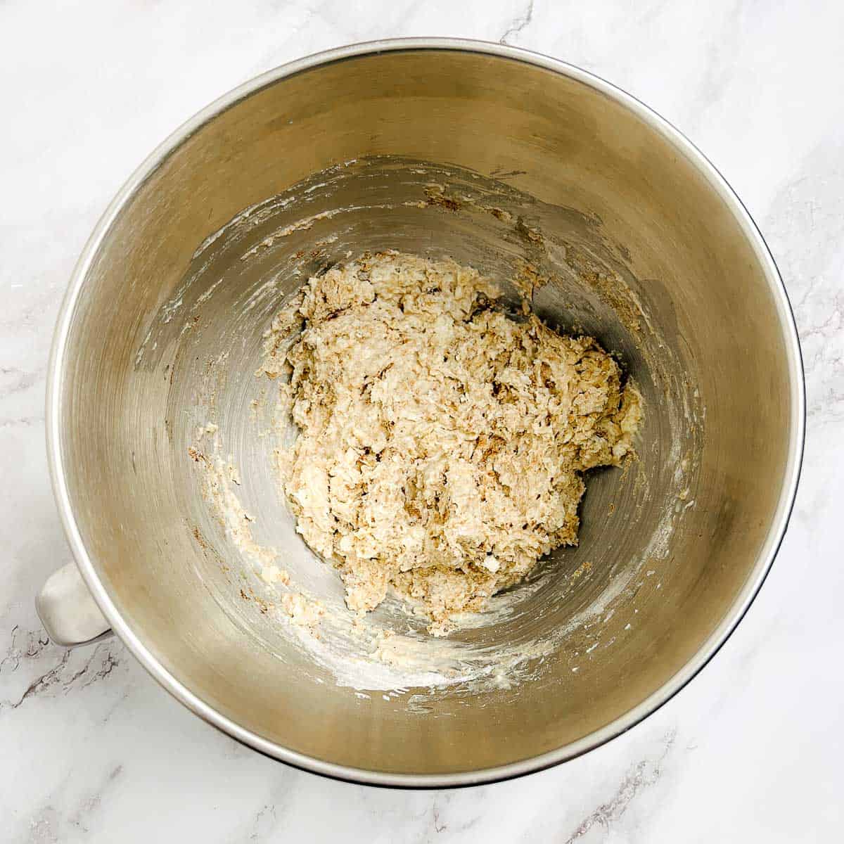 Dry ingredients mixed with soaked oats in the bowl of stand mixer.