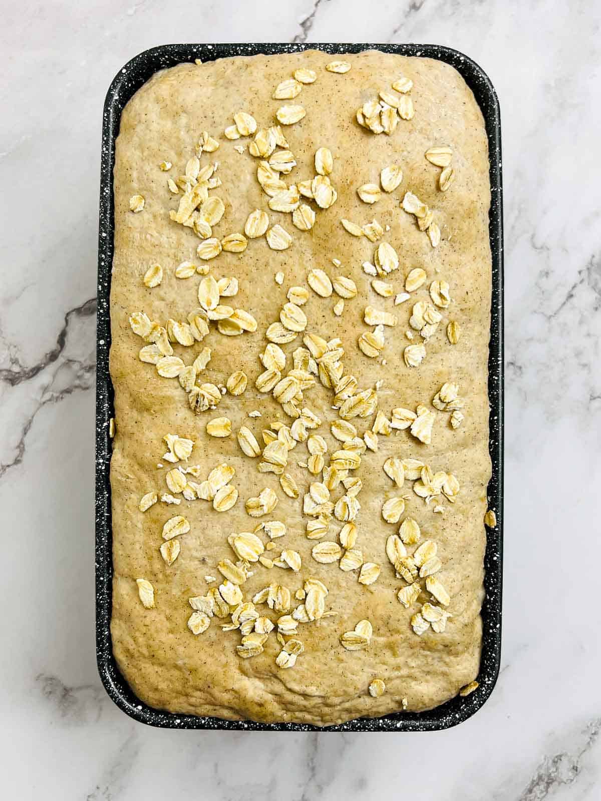 Dough topped with dry oats after the second proofing.