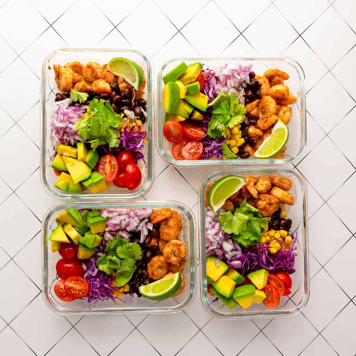 Fully assembled meal prep containers on a white surface.