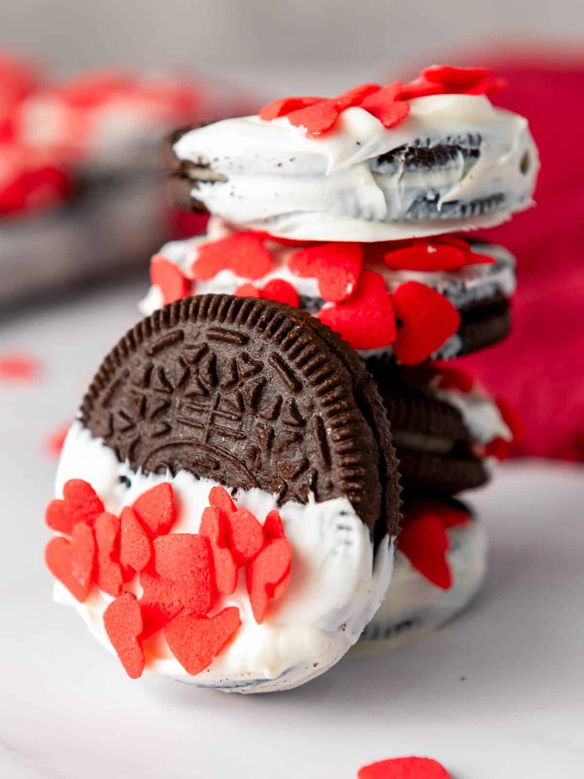 A stack of Valentine's say oreos on a white board.