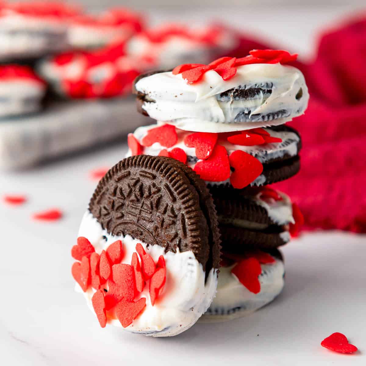 White chocolate dipped oreos on a marble surface.