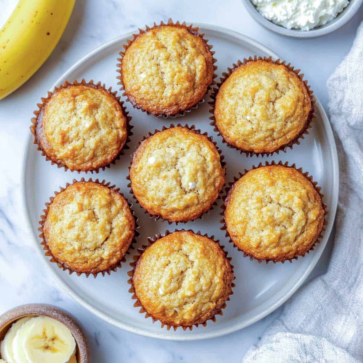 Banana cottage cheese muffins placed on a grey plate.